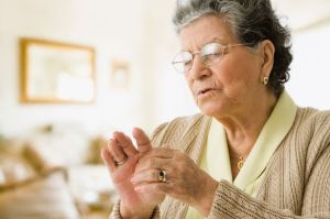Senior Hispanic woman rubbing hand